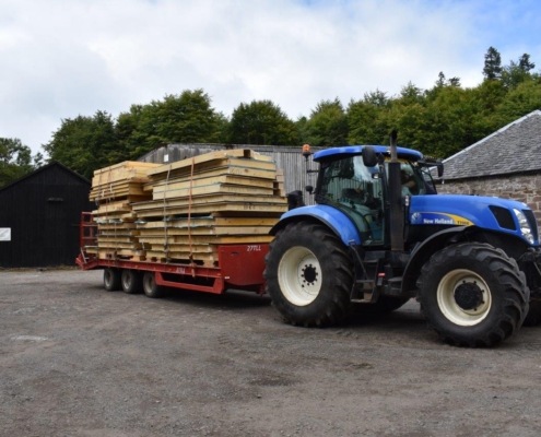 Tractor and low loader carrying wood