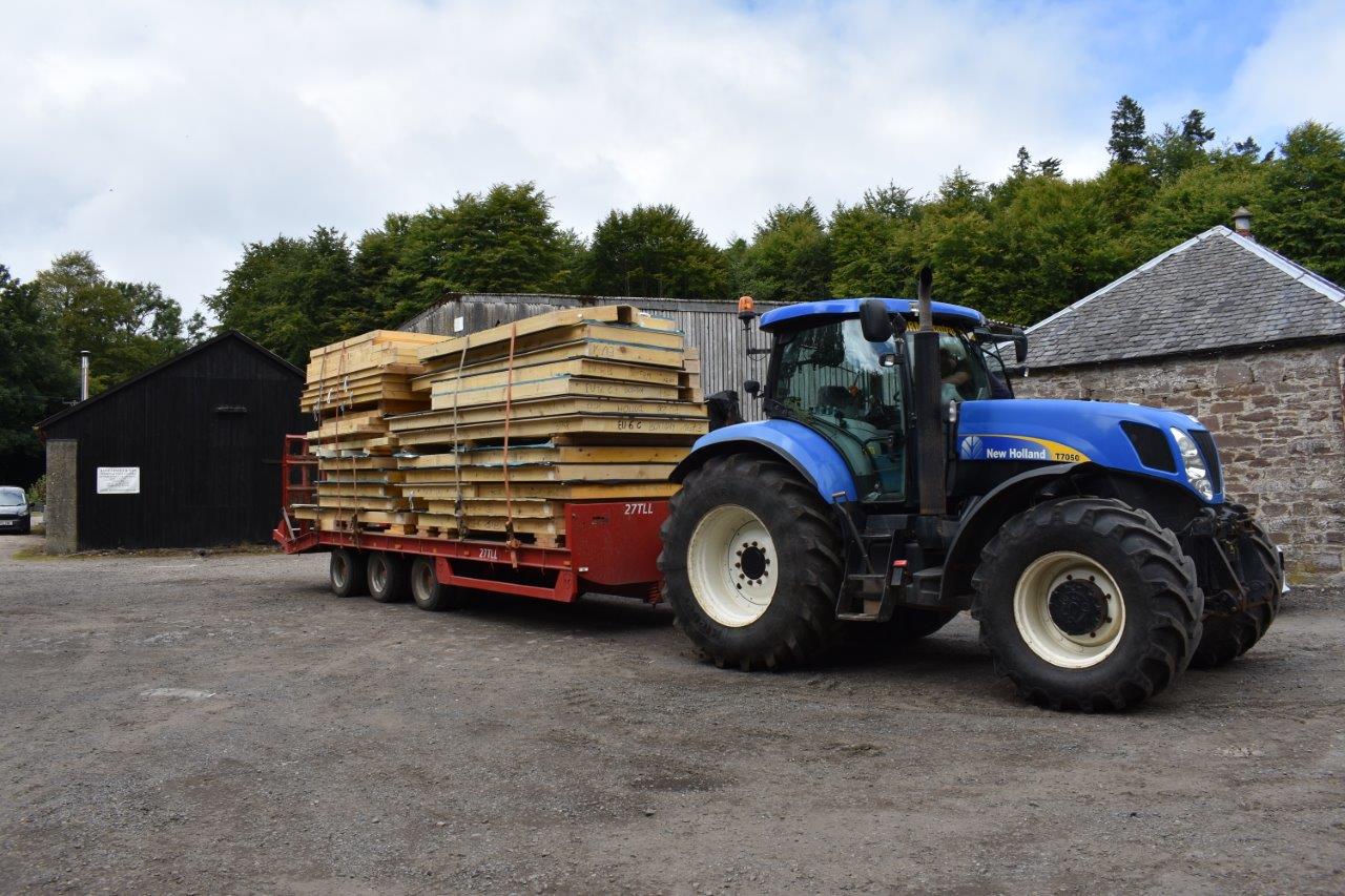 Tractor and low loader carrying wood